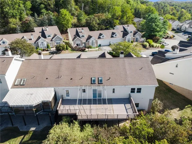 an aerial view of a house with swimming pool and outdoor seating