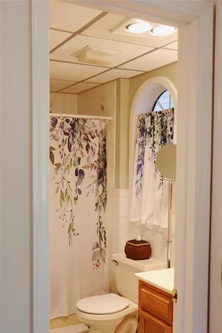 a bathroom with a toilet and shower curtain