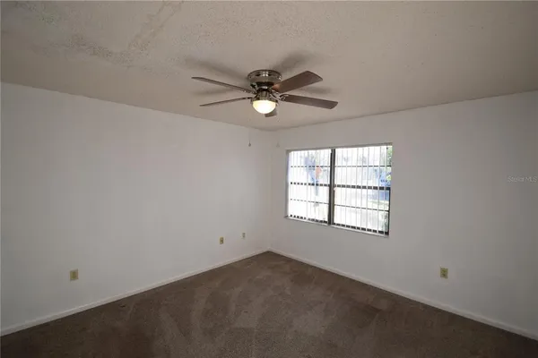 a view of a room with windows and chandelier fan
