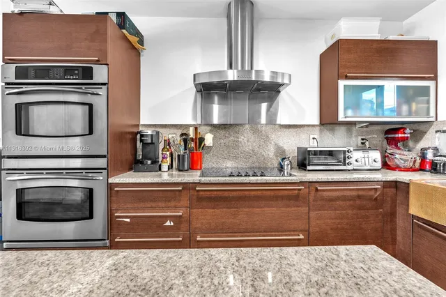 a kitchen with stainless steel appliances granite countertop a refrigerator a stove and a wooden floors