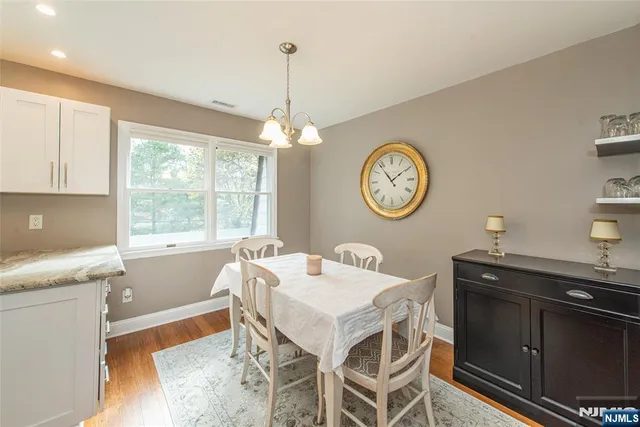 a living room with a table chairs and a large window