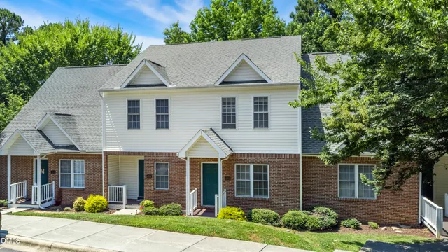 a view of a white house with a yard and potted plants