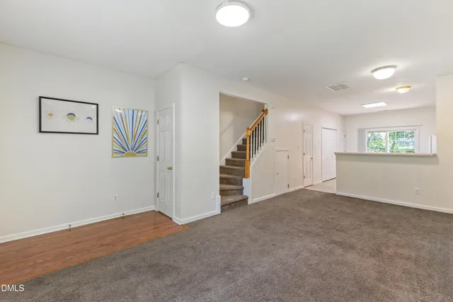 a view of an empty room with a window and stairs