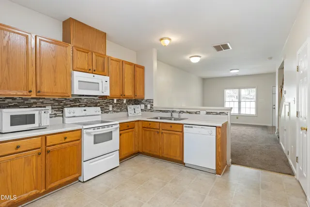 a kitchen with sink stove and cabinets