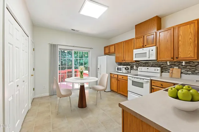 a large white kitchen with stainless steel appliances