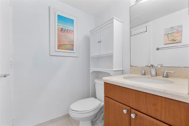 a bathroom with a granite countertop toilet sink and mirror