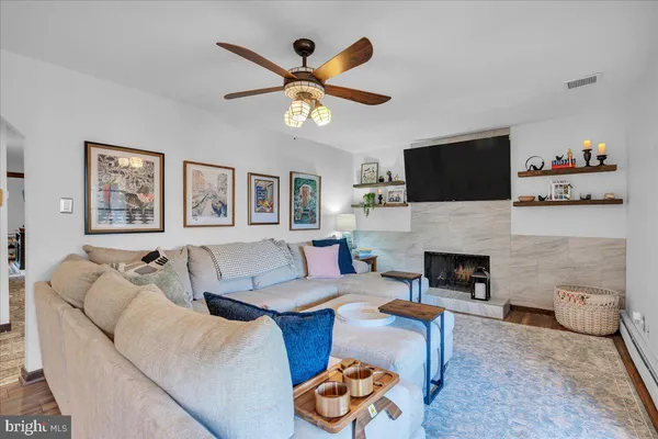 a living room with furniture a flat screen tv and a fireplace