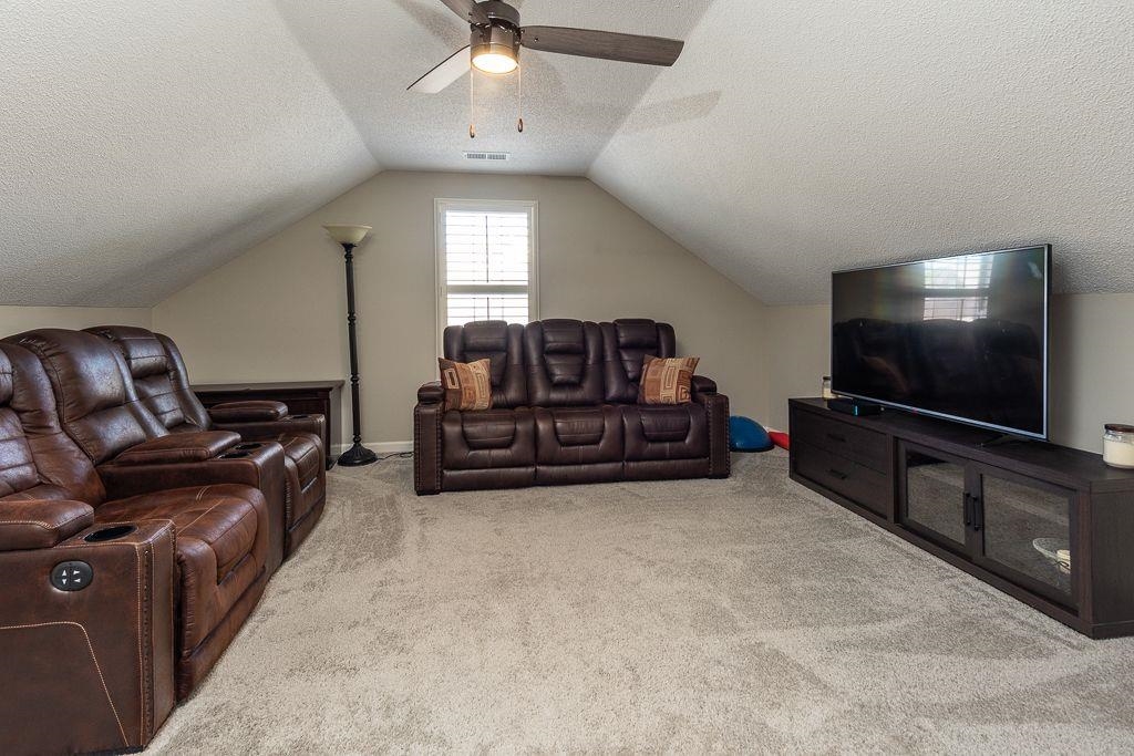 9768 Riggin Drive Memphis, TN 38002 - Photo 21 of 32 Carpeted bonus room featuring a window with plantation shutters, sloped ceilings, and a ceiling fan with integrated lighting