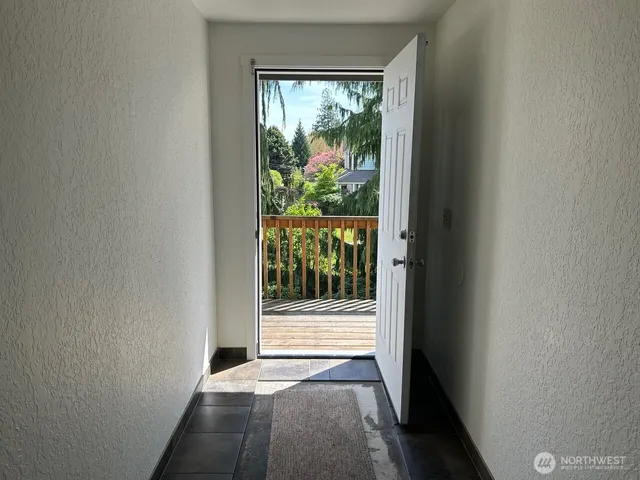 a view of a hallway with wooden floor and a window