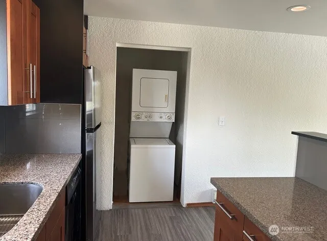 a kitchen with a granite countertop sink and refrigerator