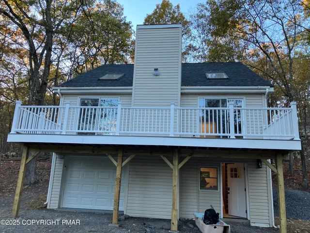 a view of a house with a yard and large tree