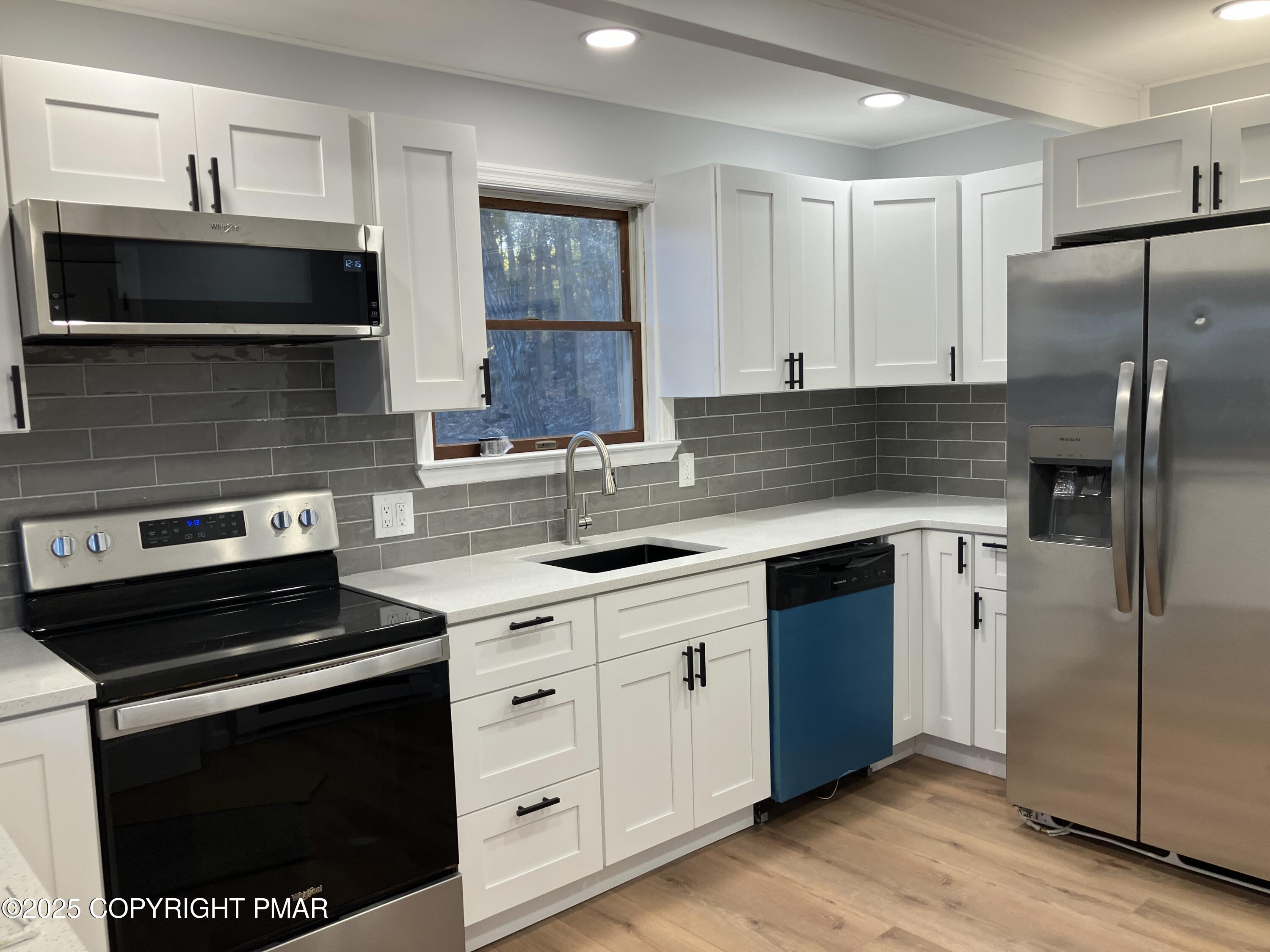 2096 Scarborough Way Bushkill, PA 18324 - Photo 24 of 38 a kitchen with cabinets stainless steel appliances a sink and wooden floor