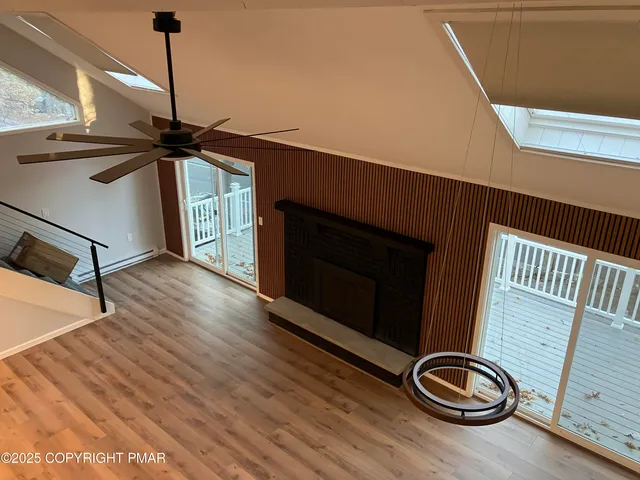 an empty room with wooden floor closet and windows
