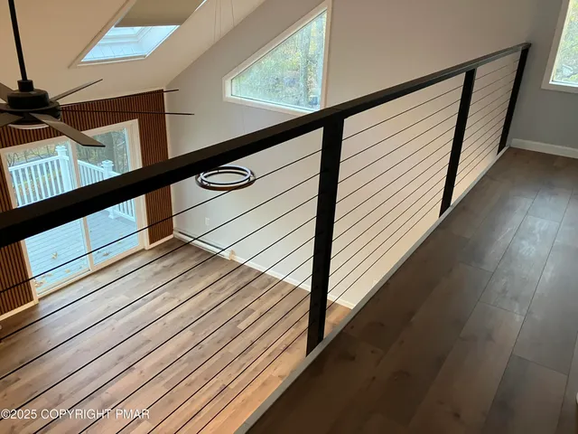 a view of a hallway with wooden floor and staircase