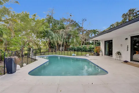a view of a swimming pool with an outdoor seating and a yard