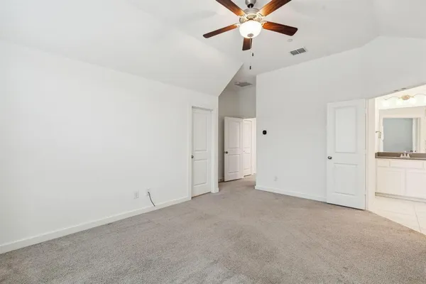 a bed sitting in a bedroom next to a bathroom