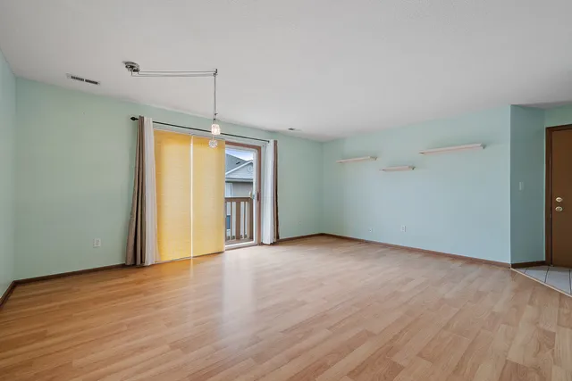 a view of a room with wooden floor and window