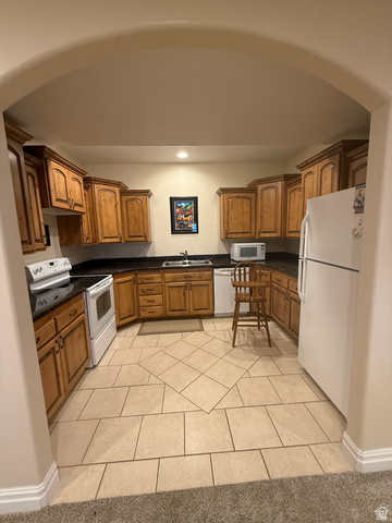 3145 South 500 West Vernal, UT 84078 - Photo 22 of 64 Basement Kitchen with wood finish cabinetry, white appliances, light tile patterned floors, and recessed lighting