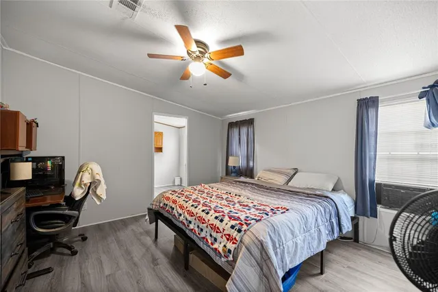 a bedroom with a bed and wooden floor