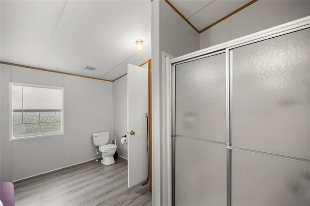 a bathroom with a toilet and a glass shower door