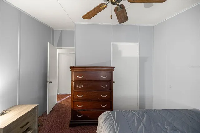 a bedroom with a dresser and a chandelier
