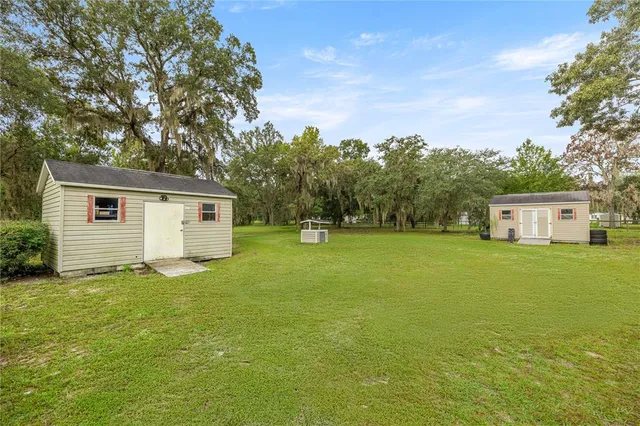a front view of a house with yard and trees