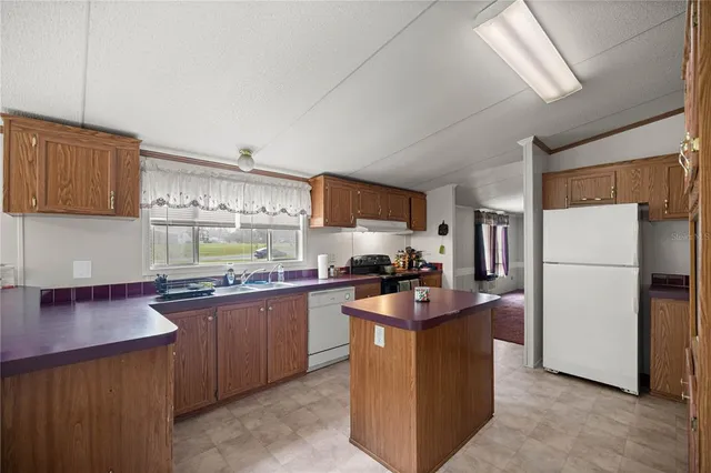 a kitchen with sink a refrigerator and cabinets