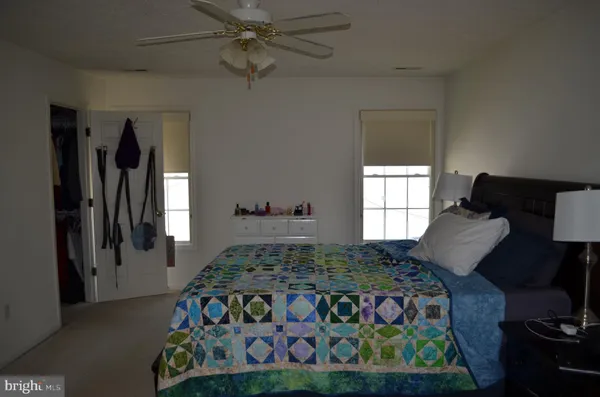 a bedroom with a bed next to a window and a flat screen tv