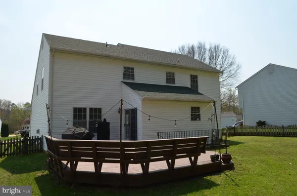 a view of a wooden bench sitting in backyard of house