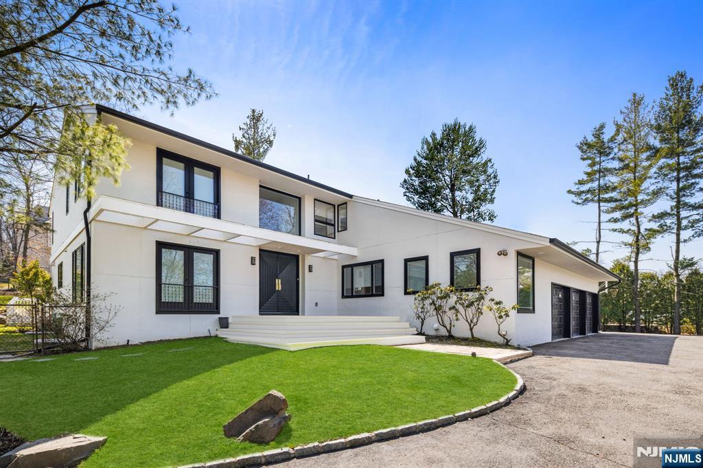1 Hemlock Drive Cresskill, NJ 07626 - Photo 1 of 26 a front view of a house with a garden and plants