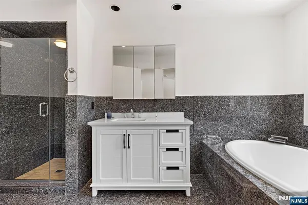 a bathroom with a granite countertop sink a toilet and mirror