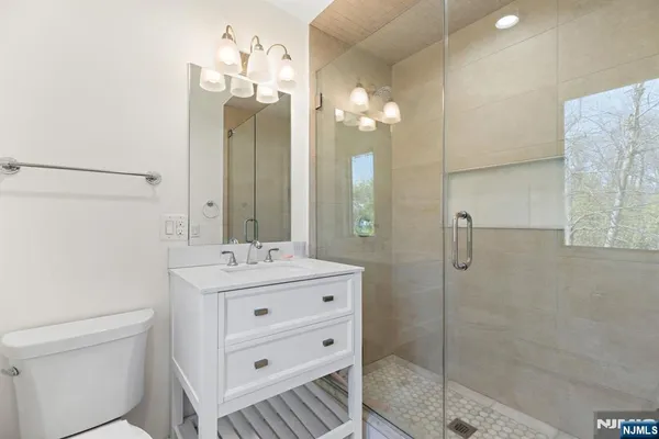 a bathroom with a double vanity sink mirror and shower