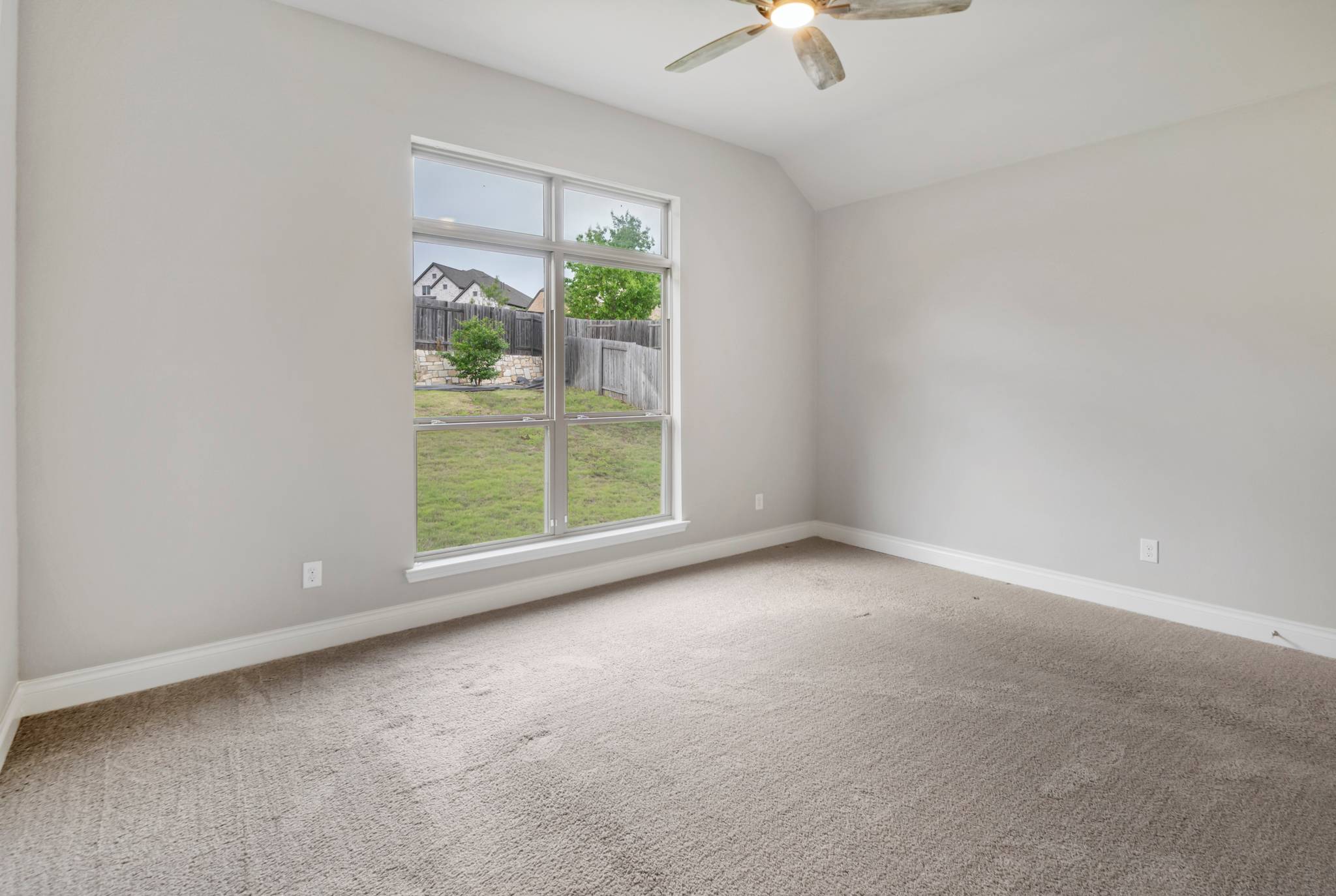 104 Catani Loop Georgetown, TX 78628 - Photo 31 of 34 A spacious bedroom with a vaulted ceiling provides a serene retreat.