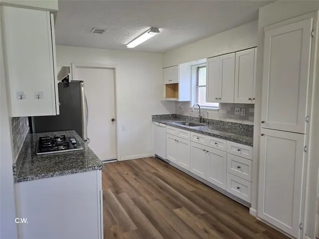 a kitchen with granite countertop white cabinets white appliances and granite counter tops