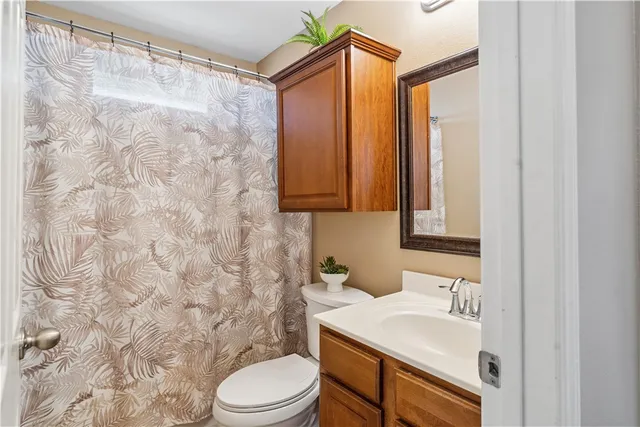 a bathroom with a sink a toilet and shower curtain