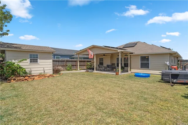 a view of a house with a backyard and a patio