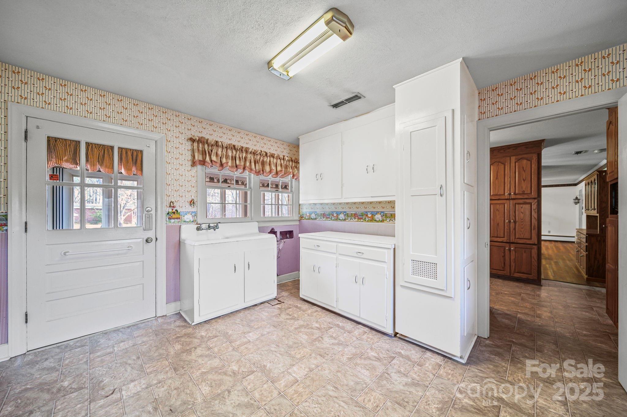 1223 Walker Road Mount Pleasant, NC 28124 - Photo 13 of 48 a kitchen with white cabinets and white appliances