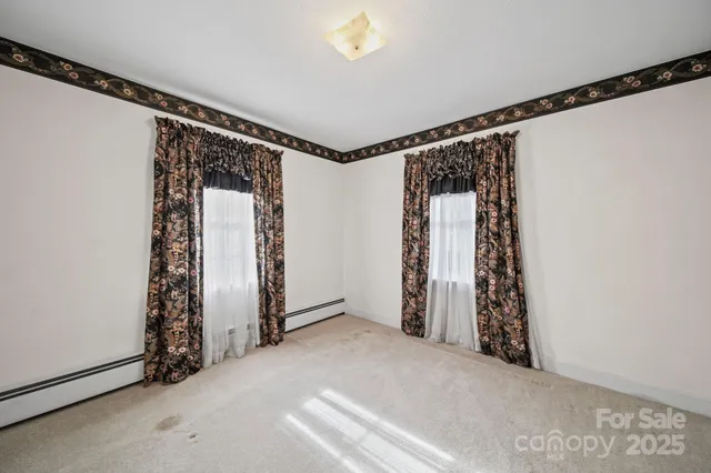 a view of an empty room with closet and a window