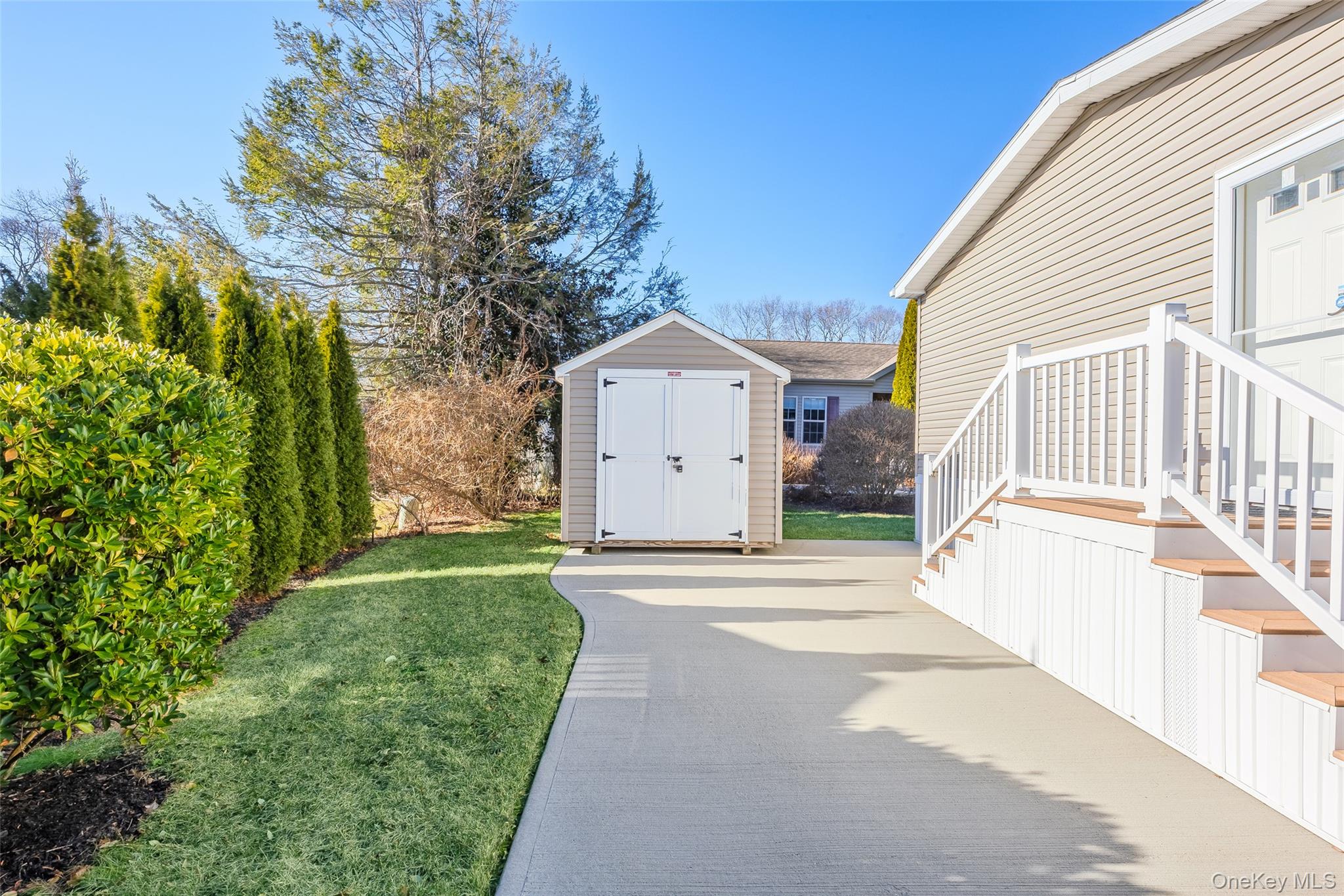 1661 Old Country Road, Unit 351B Riverhead, NY 11901 - Photo 20 of 32 a front view of a house with a yard and garage