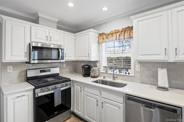 a kitchen with appliances a sink and a window