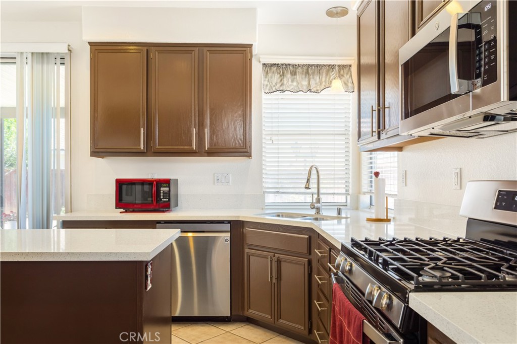 44655 Mill Run Temecula, CA 92592 - Photo 3 of 37 a kitchen with stainless steel appliances a stove and a microwave