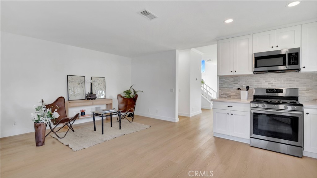 336 Fallingstar Irvine, CA 92614 - Photo 23 of 73 a kitchen with stainless steel appliances granite countertop a stove top oven a sink a dining table and chairs with wooden floor