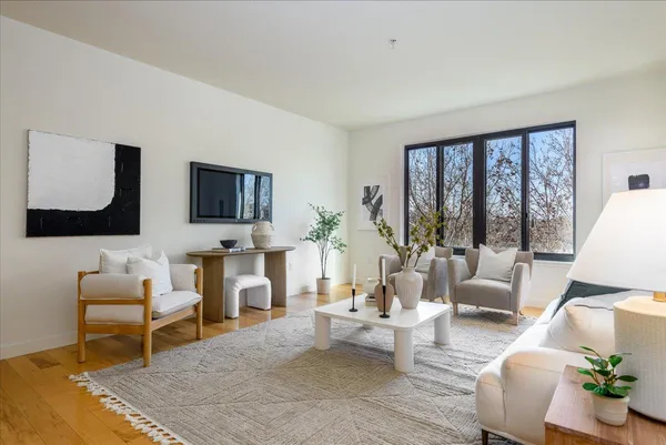 a living room with fireplace furniture and a large window