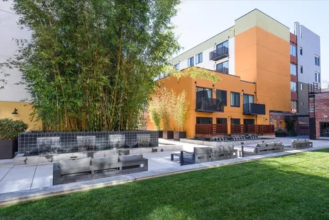 a view of a patio with couches and a table and chairs with plants and trees
