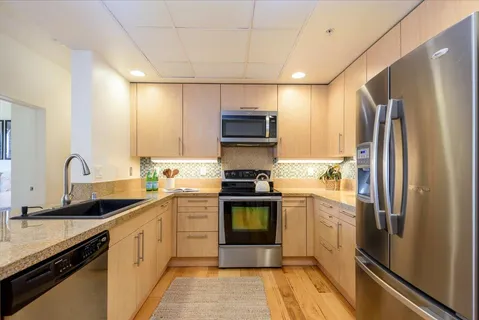 a kitchen with a sink cabinets and stainless steel appliances