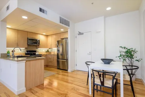 a kitchen with stainless steel appliances kitchen island granite countertop a refrigerator and microwave