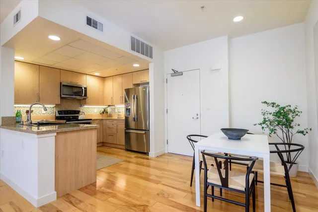 a kitchen with stainless steel appliances kitchen island granite countertop a refrigerator and microwave