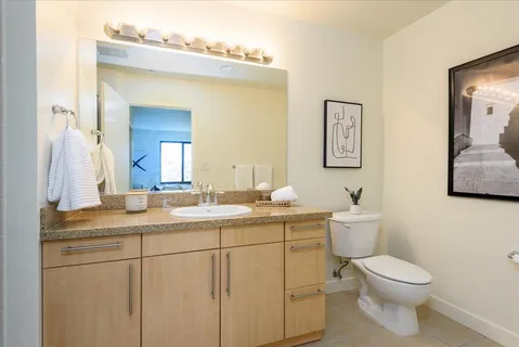a bathroom with a toilet sink and mirror