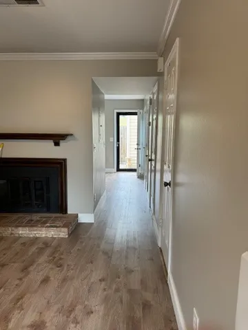 a view of a livingroom with wooden floor and a fireplace