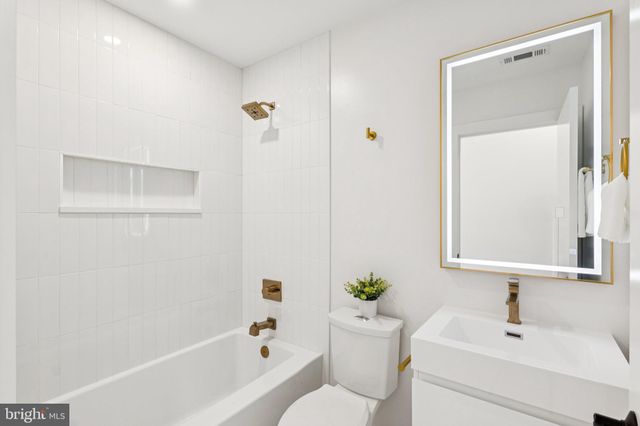 a bathroom with a bathtub a sink a toilet and a mirror